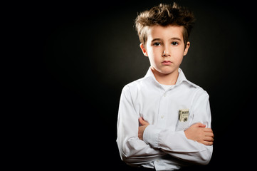 Little boy businessman portrait in low key with arms crossed