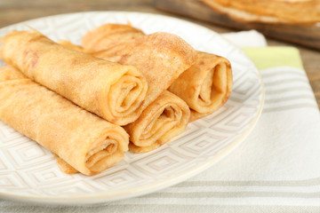 Plate of delicious pancakes on wooden background
