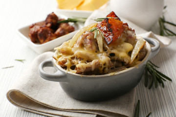 Pasta baked with vegetables and cheese in ceramic pot