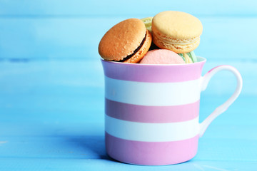 Assortment of gentle colorful macaroons in colorful mug