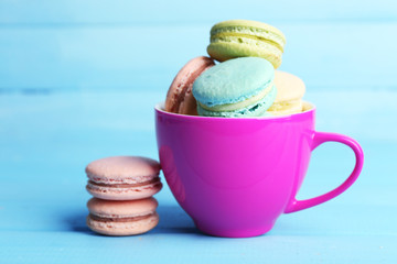 Assortment of gentle colorful macaroons in colorful mug