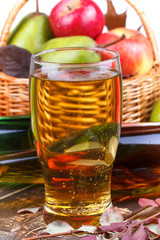 Glass and bottles of cider, fruits basket with apples and pears