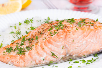 Steamed salmon with fresh herbs and lemon. Rice as a garnish