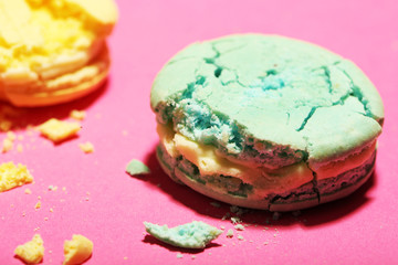 Bright tasty broken macaroons cakes on pink background