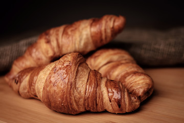 Some fresh croissants on a wooden surface