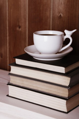 Old books and cup of coffee on table