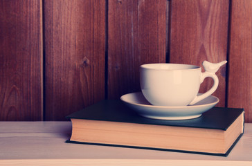 Old books and cup of coffee on table