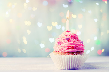 Delicious birthday cupcake on wooden table