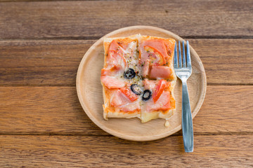 Pizza, snacks, extra plate on wood