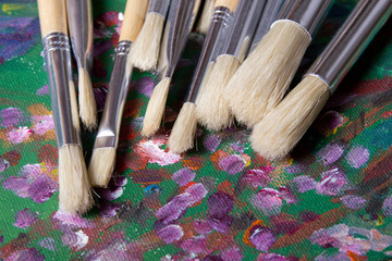 set of paint brushes on canvas background