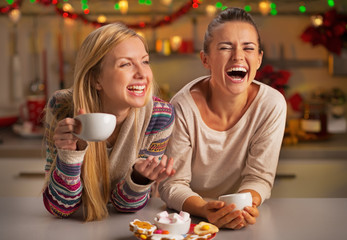 Portrait of laughing girlfriends having christmas snacks