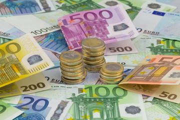 Münzstapel auf viele verschiedene Geldscheine