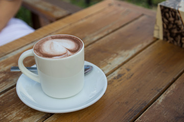a cup of expresso coffee with heart-shape foam on top