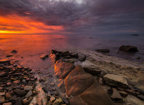  zachód słońca nad morską, skalistą plażą © Mike Mareen