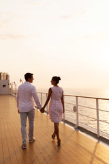 rear view of couple holding hands walking on cruise ship