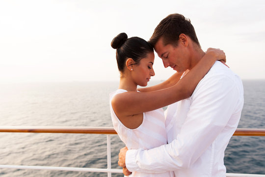 young couple hugging with eyes closed on cruise