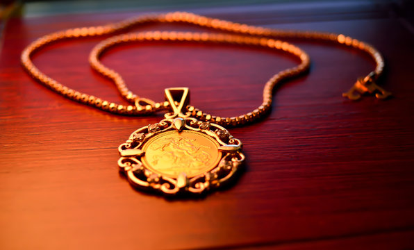 Gold sovereign coin as woman’s jewelry pendant on a chain