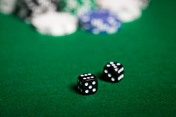 close up of black dices on green casino table