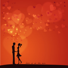 Love is in the air: Silhouette of two lovers on a red background
