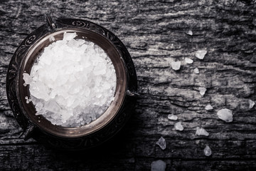 sea salt in an old utensils on wooden table