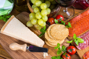 Parmesan cheese with appetizer salami oat crackers and grapes