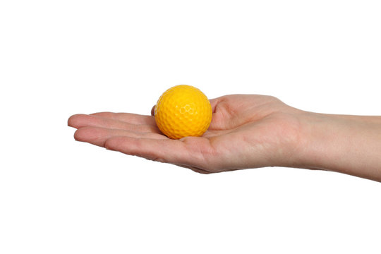 Yellow golf ball in hand isolated on white background