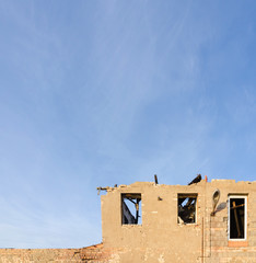 detail of a an old demolished building in front of a blue sky