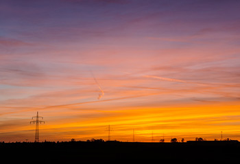 power line silhouettes in front of a colorful sunset sky
