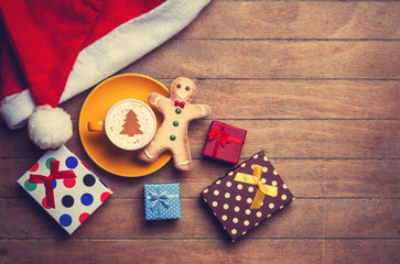 Cappuccino with gingerbread man on wooden table.