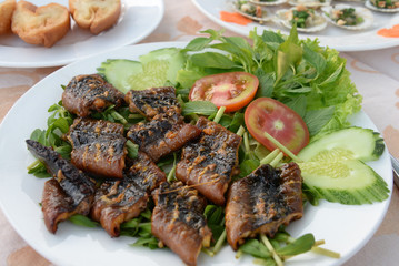 Close up of fried eel with vegetables and greens