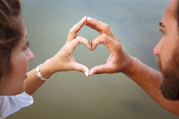 Man and woman's hands in heart shape