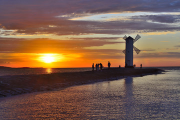 Naklejka premium Sunset over the sea with lighthouse