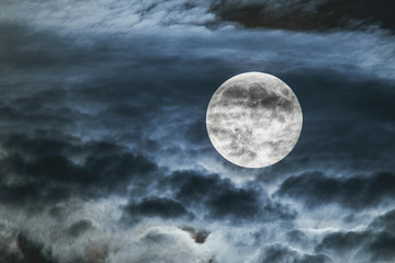 Full Moon behind faint clouds