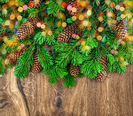 christmas tree branches with cones and colorful lights