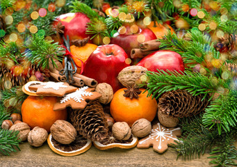 Fruits, cookies and spices. Christmas background with lights