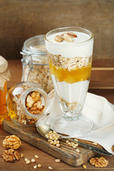 Tasty dessert with oat flakes and honey, on table