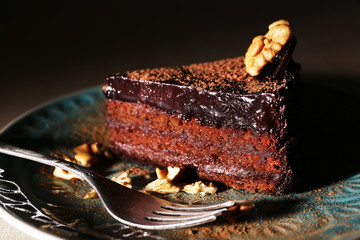 Delicious chocolate cake on plate on dark background