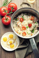 Tasty rice in pan on wooden table