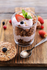 Healthy layered dessert with muesli and berries on table