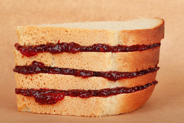 Tasty sandwich with jam, on brown background