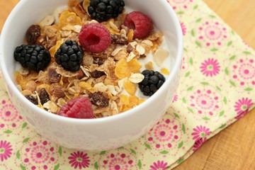 Bowl of breakfast healthy muesli and corn flakes with berries.
