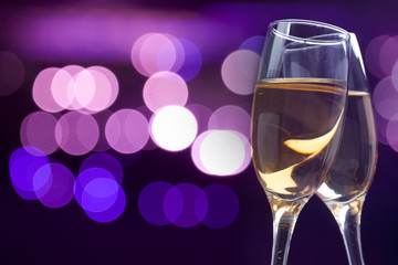 Champagne glasses against holiday lights