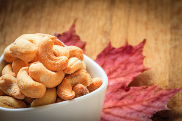 Cashew nuts in bowl on wooden background