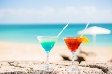 Two tropical cocktails on beach ocean white sand seascape