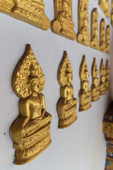 golden buddha sculpture on the temple wall