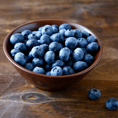 Fresh blueberries in a bowl of wooden boards