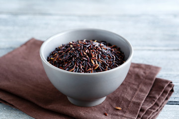 Raw black rice in a gray clay bowl