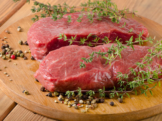 Raw beef steak on a   board.