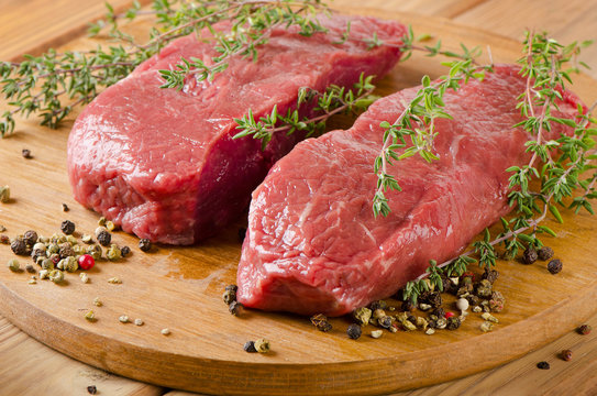 Raw beef steak on    board.