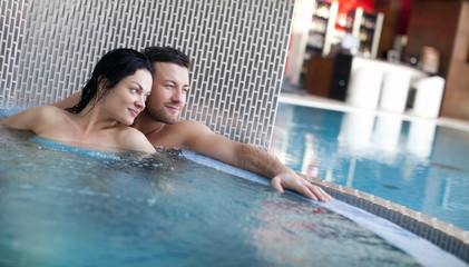 Couple relaxing in jacuzzi of spa center 